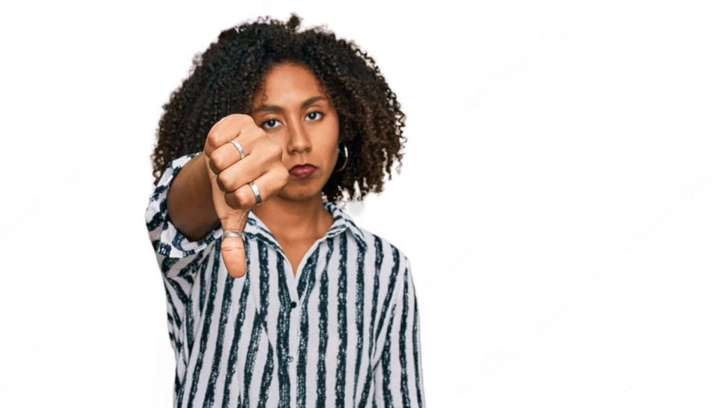 Woman looking annoyed with her thumb facing down