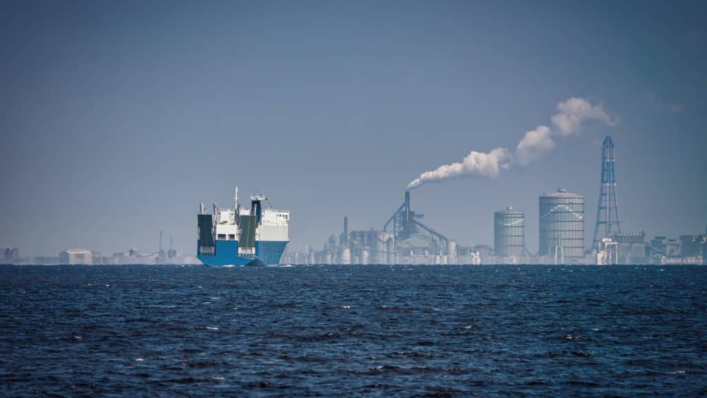 container ship and factory generating pollution